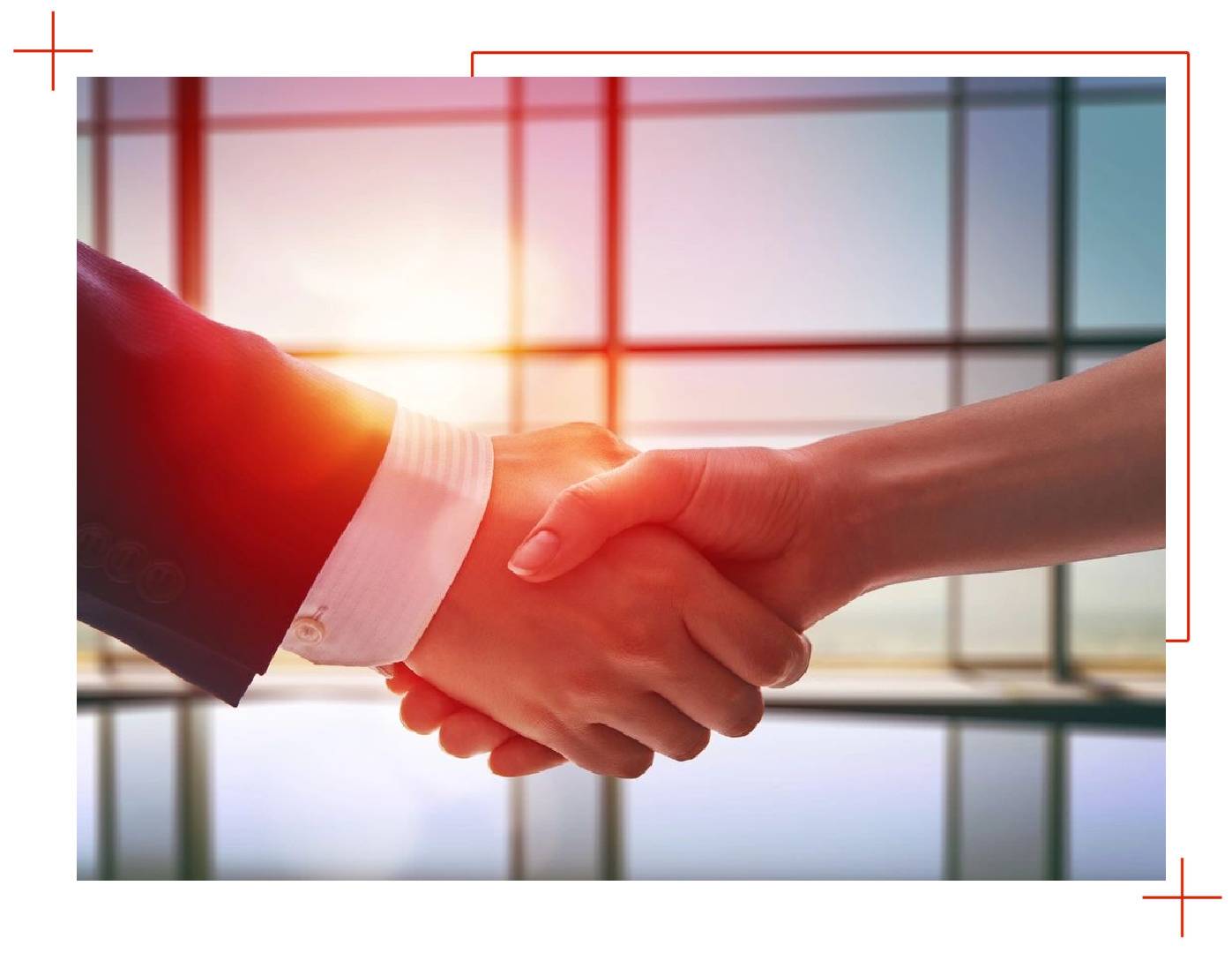 Two people shaking hands in front of a window.